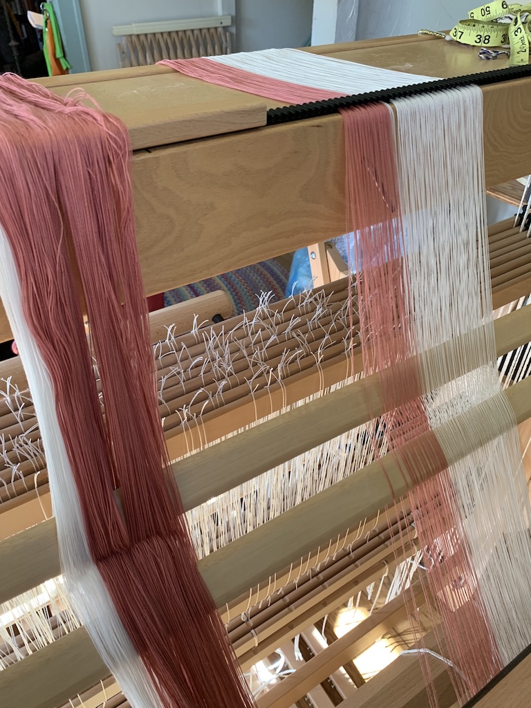 Spreading warp on the raddle in preparation for winding onto back beam.