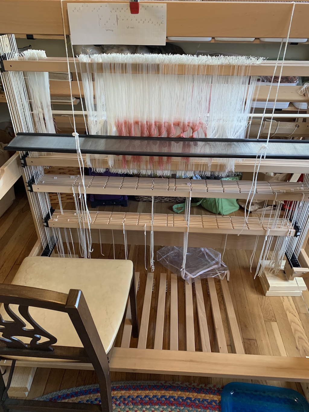 Sleying the reed.